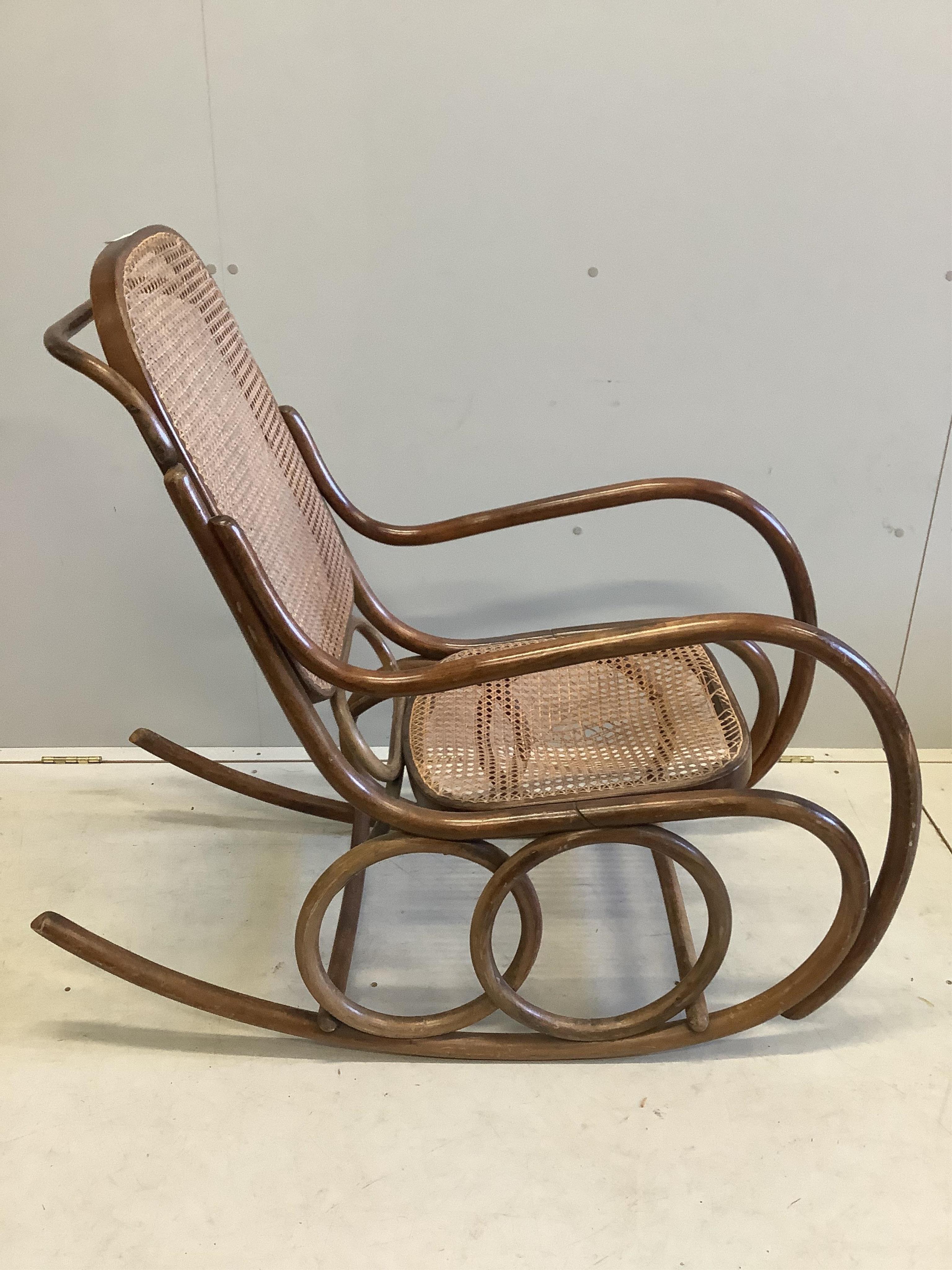 An early 20th century caned beech bentwood rocking chair, width 50cm, depth 112cm, height 98cm. Condition - fair, cane poor